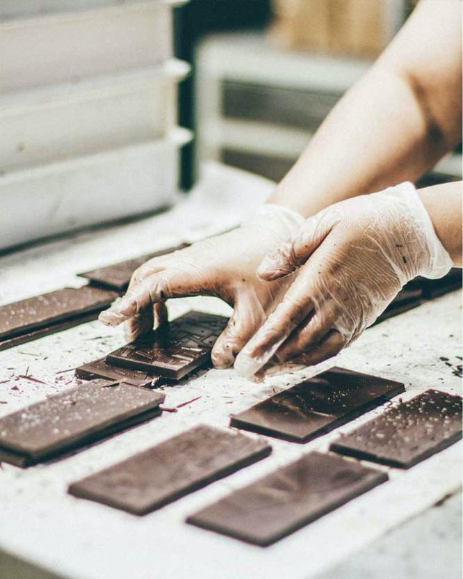 Chocolate bars being demolded by hand
